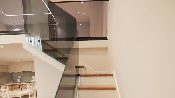 A modern staircase with glass railings and wooden steps leading to an upper floor. - Duplex City 03 in Durr s (Durrës)