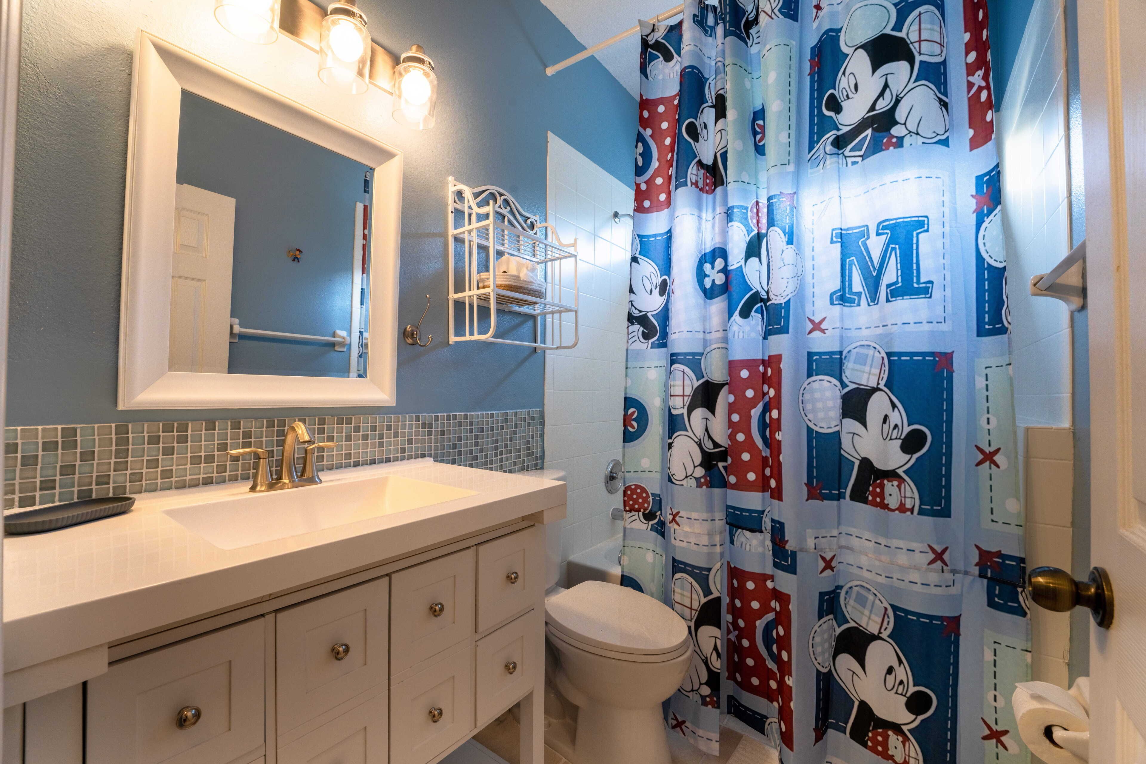 A bathroom with a sink, mirror, and toilet.