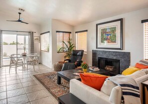 A spacious living room with a fireplace, a dining area with a table and chairs, and a balcony with a view. - Vegas Designer Private Pool Oasis, King Suite, BBQ (Las Vegas)