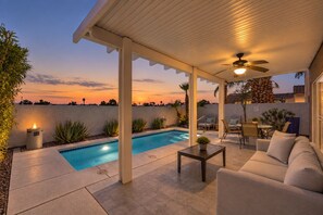 A covered outdoor area with a pool, seating, and a ceiling fan. - Vegas Designer Private Pool Oasis, King Suite, BBQ (Las Vegas)