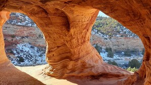 Formación rocosa natural con inscripciones labradas, que ofrece vistas de un paisaje nevado.