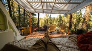 Un dormitorio con vistas a una terraza de madera y zona de estar exterior.