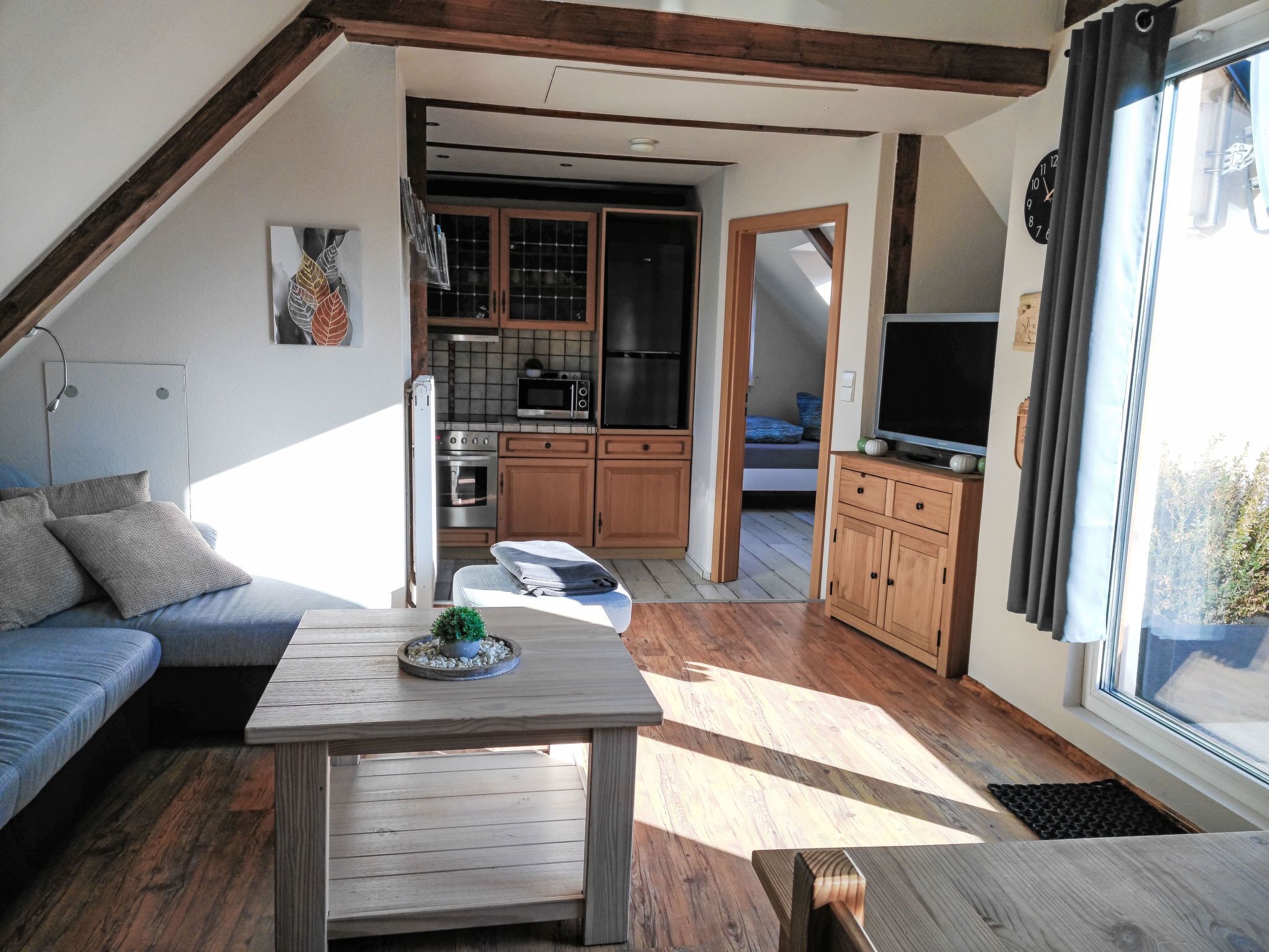 A loft-style living space with a kitchen, a dining area, and a sleeping area.