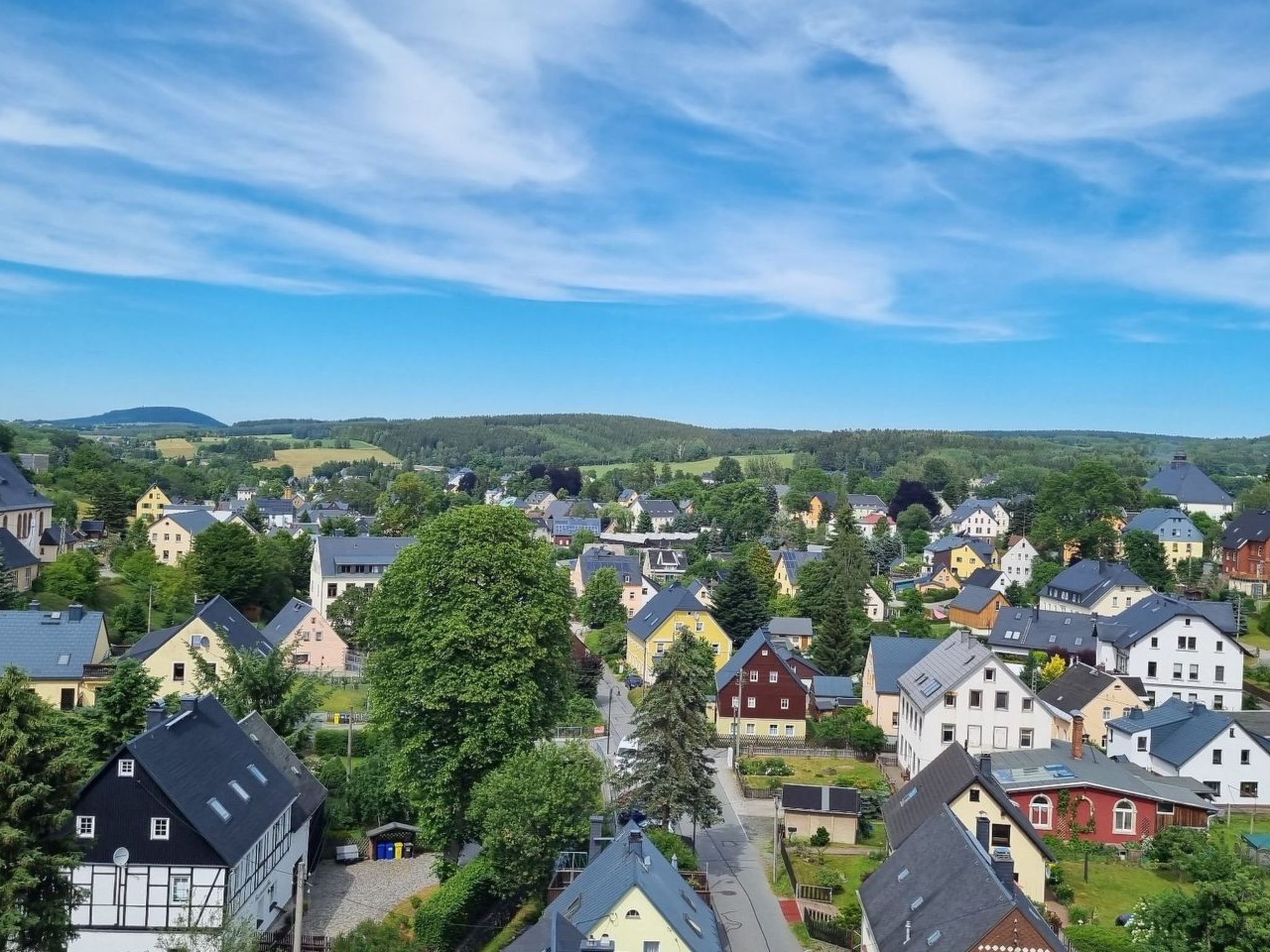 A residential area with houses, trees, and a clear sky.