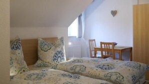 Ein Schlafzimmer mit einem Bett, einem Sessel und einem kleinen Tisch.