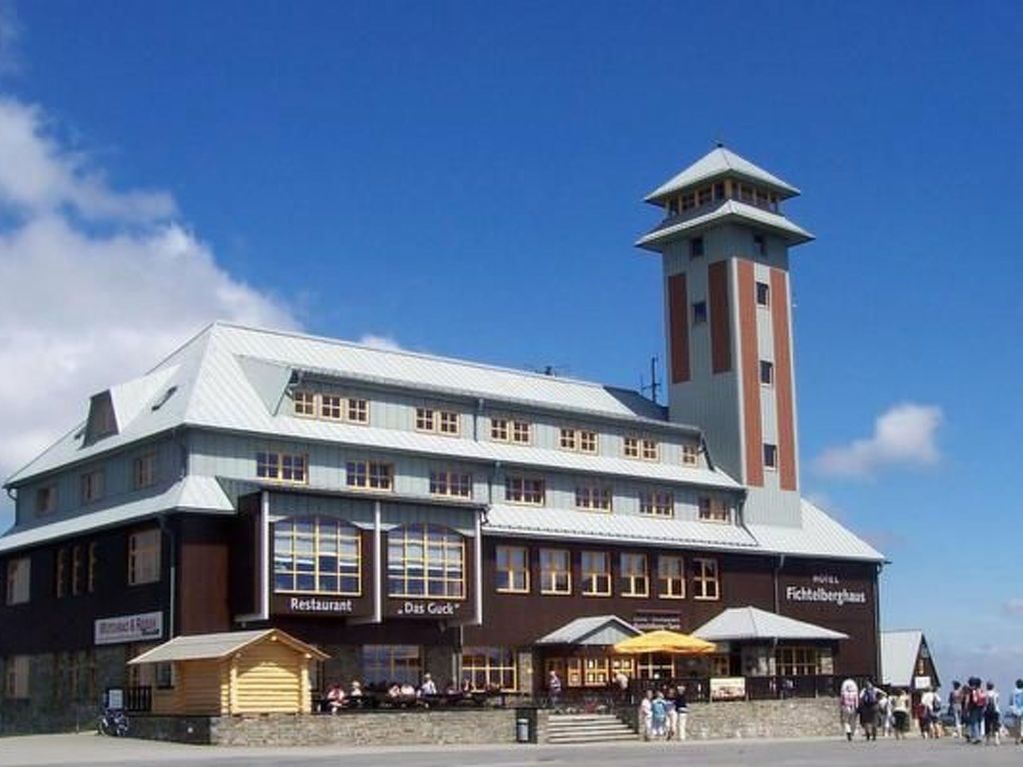 Ein Gebäude mit Restaurant, Bar und einem Turm.