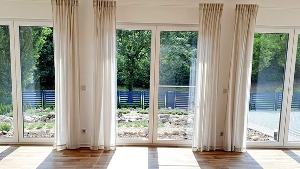 A spacious room with large sliding glass doors leading to a garden area. - Ferienhaus by Interhome (Frankfurt / Oder)