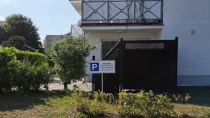 A paved driveway leading to a building with a parking sign. - 2 Raum  Graal-Müritz by Interhome (Graal Müritz)
