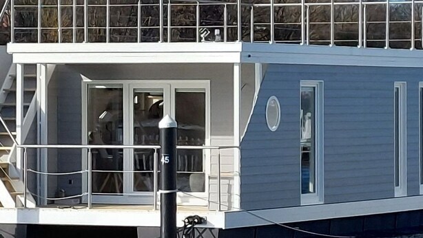 A houseboat with a covered deck, large windows, and a small circular window on the side. - Hausboot Tosca by Interhome (Stralsund)