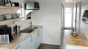 A compact kitchen with white cabinetry, a microwave, a coffee maker, and a sink. - Hausboot Tosca by Interhome (Stralsund)