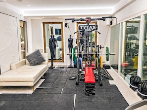 A home gym with a bench press, weight racks, and a mirror. - UG Neubau City by Interhome (Munich)