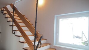 A wooden staircase with a glass railing leading to a landing. - Haus an der Lieser by Interhome (Spittal an der Drau)