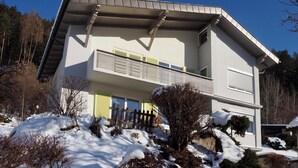A two-story house with a balcony, surrounded by snow-covered ground and trees. - Haus an der Lieser by Interhome (Spittal an der Drau)
