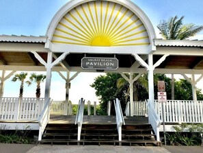A pavilion with a sun motif, labeled 'Delray Beach Pavilion 1929-2014', and a sign indicating it is closed from 5 PM to 6 AM.