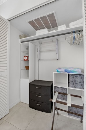 A compact storage area with a built-in shelf, a drying rack, and a small cabinet.