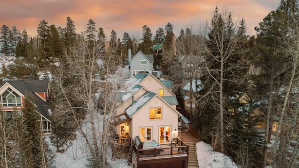 A snow-covered landscape with a house featuring a deck and a garage. - Raven 7 minute walk to Main St/Downtown Breck. Hot tub! (Breckenridge)