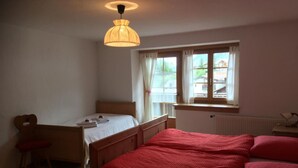 Un dormitorio con una cama de madera, un escritorio y una ventana con cortinas.