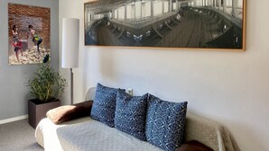 Een moderne hotelkamer met een groot bed, een potplant, een wanddecoratie en een groot raam.