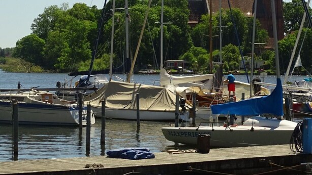 A marina with several sailboats docked, a wooden dock, and a building in the background. - Gemütliches Dachgeschoss-Apartement mit Seeblick und großem Garten am Wasser by Interhome (Ludorf)