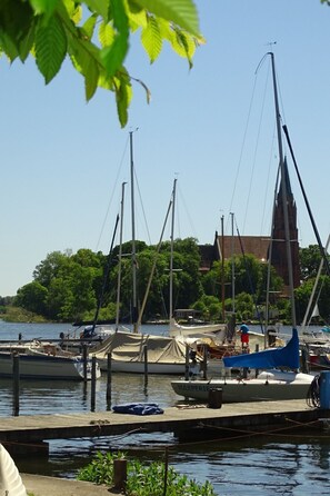 A marina with several sailboats docked, a wooden dock, and a building in the background. - Gemütliches Dachgeschoss-Apartement mit Seeblick und großem Garten am Wasser by Interhome (Ludorf)