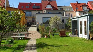 A residential area with houses featuring red-tiled roofs, a paved pathway, and green lawns. - Gemütliches Dachgeschoss-Apartement mit Seeblick und großem Garten am Wasser by Interhome (Ludorf)