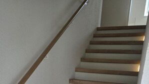 Un escalier avec des marches en bois et des murs blancs.