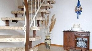 Eine Wendeltreppe mit Holzbodenstufen und Metallgeländern, die zu einer oberen Etage führt.