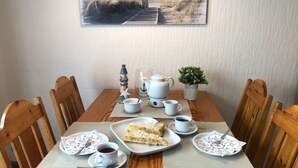 Ein Esstisch mit einem Teller Essen, Tassen und einer Teekanne.