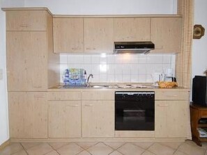 Een koelkast, een magnetron, een oven, kookgerei, borden en bestek