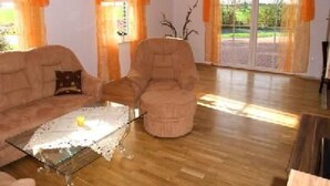 Ein Wohnzimmer mit Sofa, Sessel und Couchtisch.