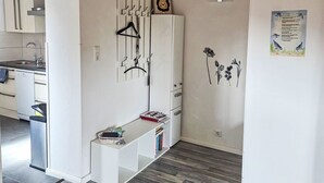 Eine moderne Küche mit weißen Schränken, einem integrierten Geschirrspüler und einer Edelstahl-Spüle.