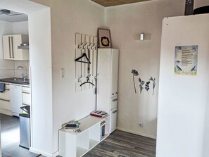 Una cocina moderna con armarios blancos, lavavajillas integrado y pileta de acero inoxidable.