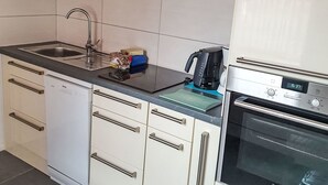 Eine Küche mit Geschirrspüler, Kaffeemaschine und Backofen.