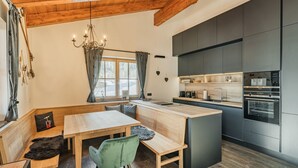 Een moderne keuken met donkere kastjes, een houten eiland en inbouwapparatuur.