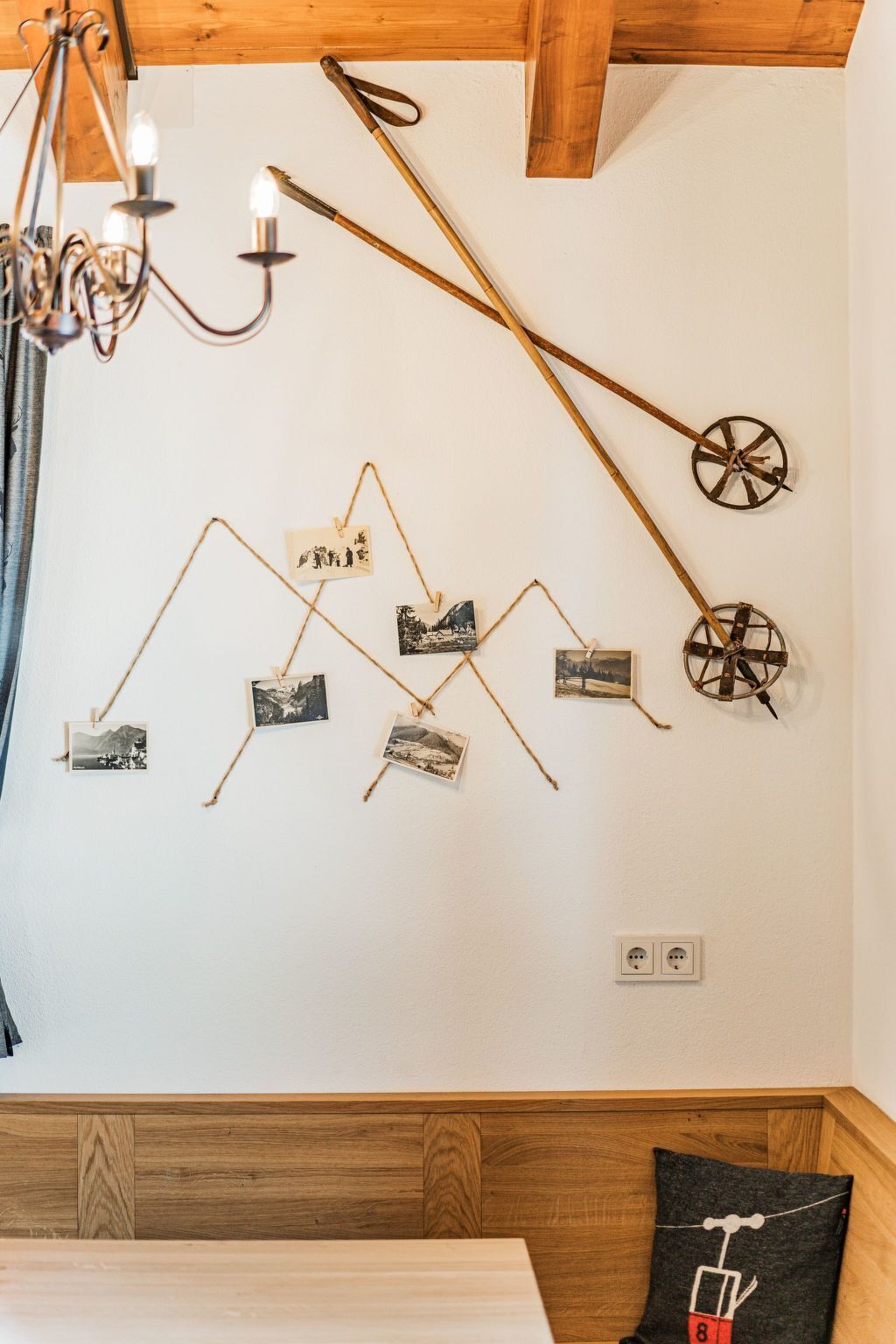 A wall with photos and a chandelier.