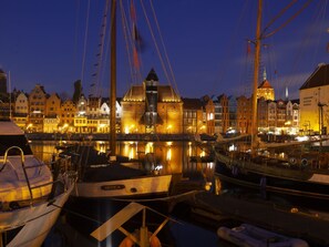 A marina at dusk with boats docked, a prominent building with a tower, and a building with a sign reading "Narodowe Muzeum Morskie". - Altstadt-Wohnung Angielska Grobla by Interhome (Gdansk)