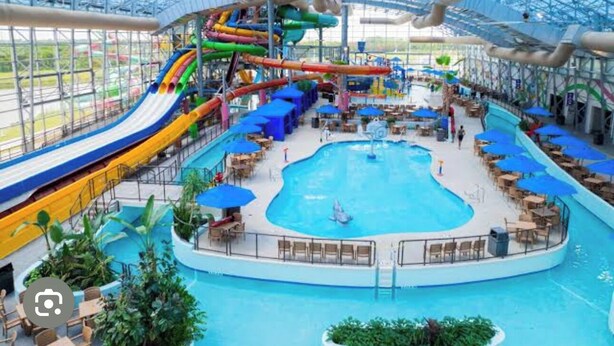 Un parc aquatique intérieur doté d’une grande piscine, de toboggans et d’espaces de détente.
