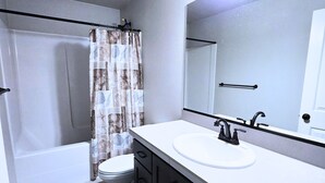 Un bagno con vasca, water e lavandino.