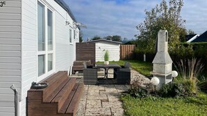 A residential backyard with a patio, seating area, and a stone structure. - Haus Moony by Interhome (Wervershoof)