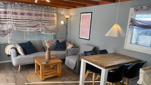 A modern living room with a sofa, coffee table, and dining table. - Haus Moony by Interhome (Wervershoof)