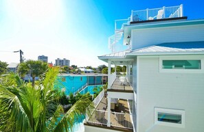 Un immeuble à plusieurs étages doté de balcons, d’une piscine et offrant une vue sur le panorama urbain.