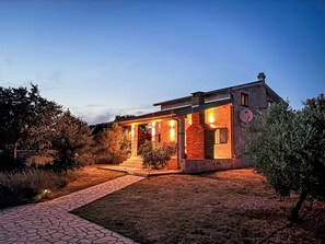 A modern house with a covered porch, a brick chimney, and a satellite dish. - Anwesen "Steinperle mit beheiztem Schwimmbad" by Interhome (Donje Rastane)