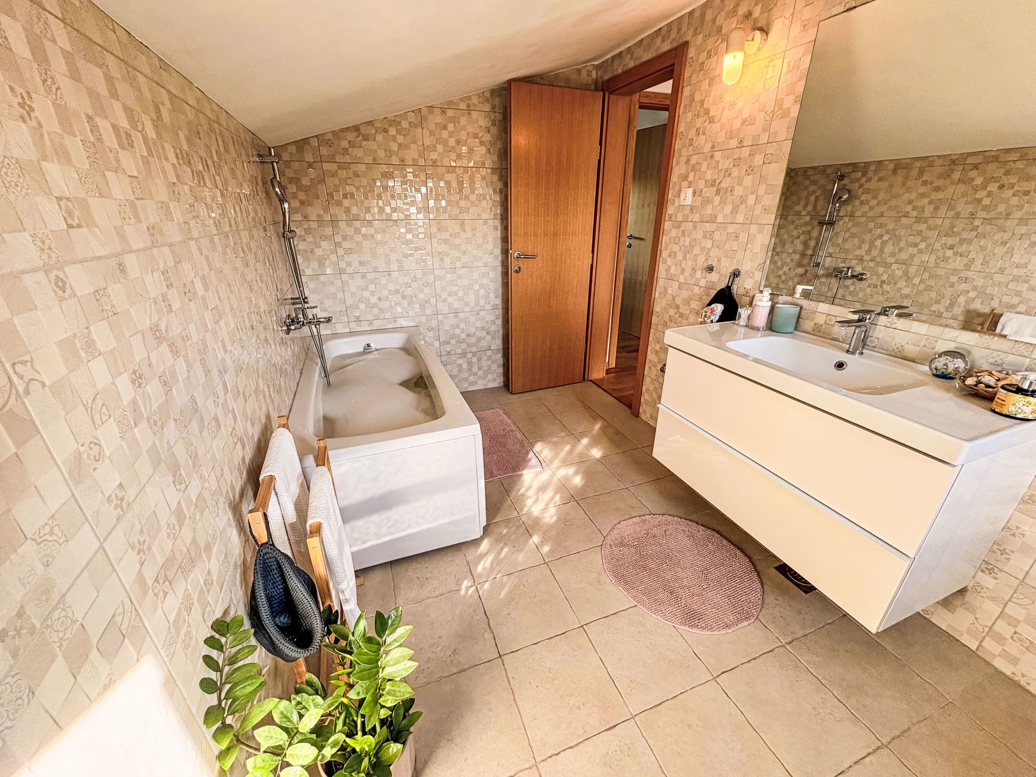 A bathroom with a bathtub, a sink, and a mirror.
