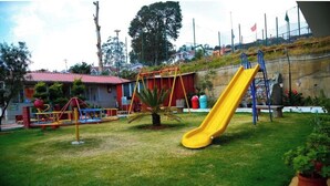 A playground with a yellow slide, swings, and a climbing structure.
