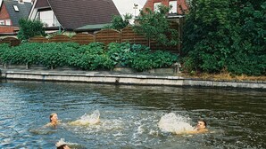 Een zwembad met daarin drie personen.