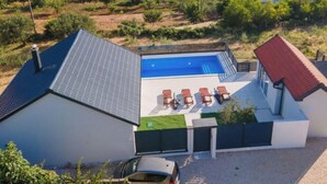A modern house with a swimming pool, solar panels, and a fenced garden. - "Luxury Grey house" by Interhome (Domanovići)