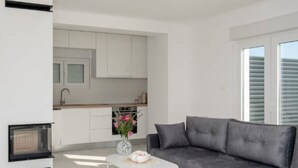 A modern living room with a grey sofa, a white coffee table, and a pet bed. - "Luxury Grey house" by Interhome (Domanovići)