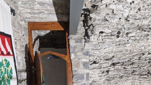 A narrow stone-walled corridor with a wooden bench and a metal railing. - Schloss Ballindooley by Interhome (Dingle)