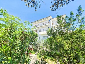 A multi-story building with balconies, surrounded by lush greenery and trees. - Wohnung für 4 Personen, 100m vom Strand entfernt by Interhome (Crikvenica)