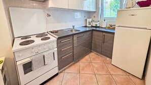 Eine Küche mit Herd, Backofen, Spüle und Kühlschrank.